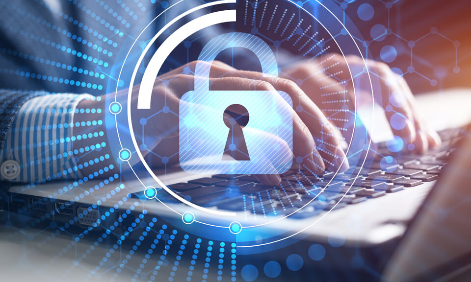 Business man typing on a laptop with a security shield icon superimposed over the image