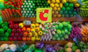 Stacked fruit and vegetables on packed shelves, with Big C logo