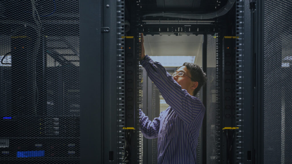 Network IT professional in server room working on racks