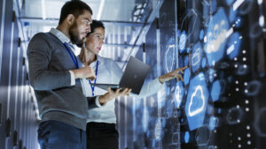 technicians holding a laptop in a data center