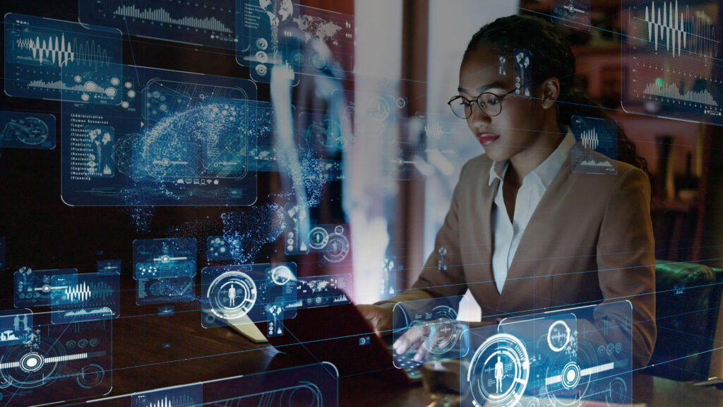 Business woman on a laptop with IoT screens superimposed