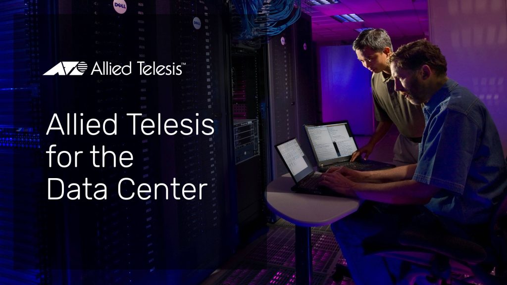Two men working on laptops in a datacenter